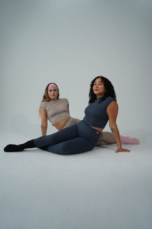 A woman foam rolling and stretching to prioritize recovery for women athletes.