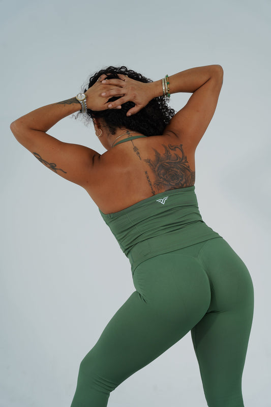 A strong woman wearing premium activewear demonstrating how to get a toned stomach using core compression mechanics on a studio mat.