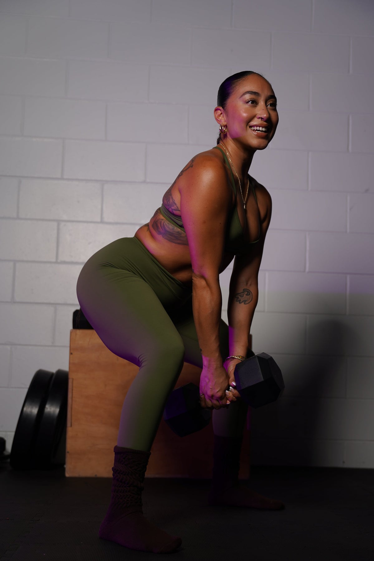 A woman smiling while learning how to stay consistent with workouts.