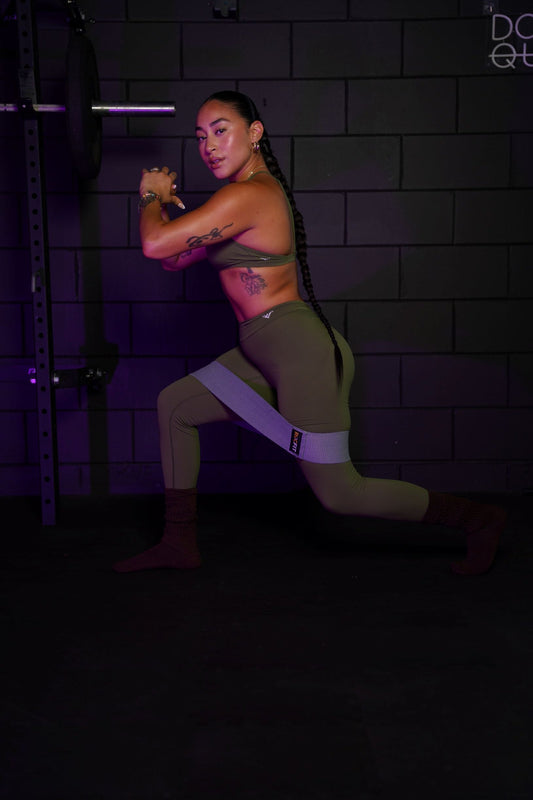 Woman performing a resistance band glute workout for hip stability and muscle growth.