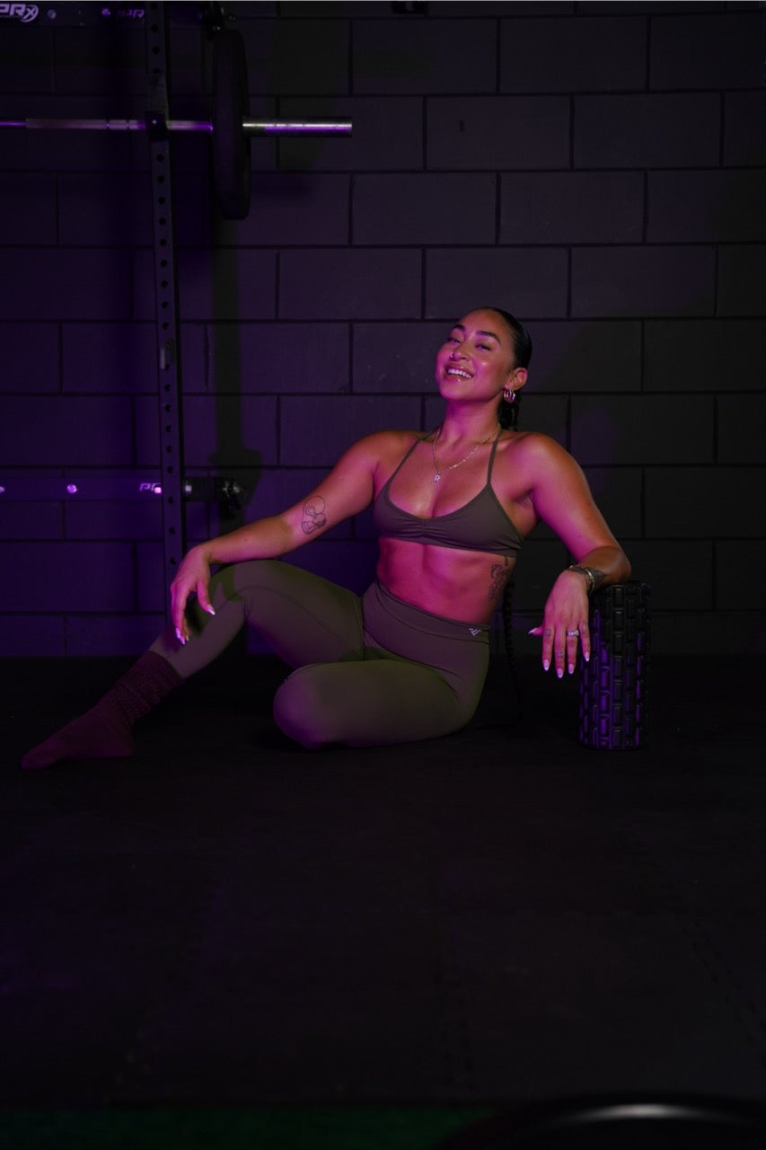 A close-up shot of a woman's midsection and waist as she wears supportive athletic activewear.